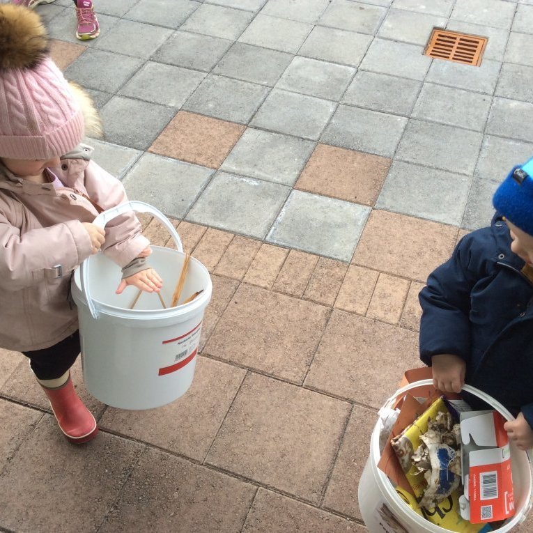 Börnin flokka rusl og fara með það út í stóru tunnurnar