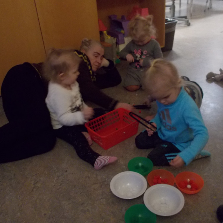 börnin einbeita sér í að ná litlum kúlum með töngum - æfing í fínhreyfingum